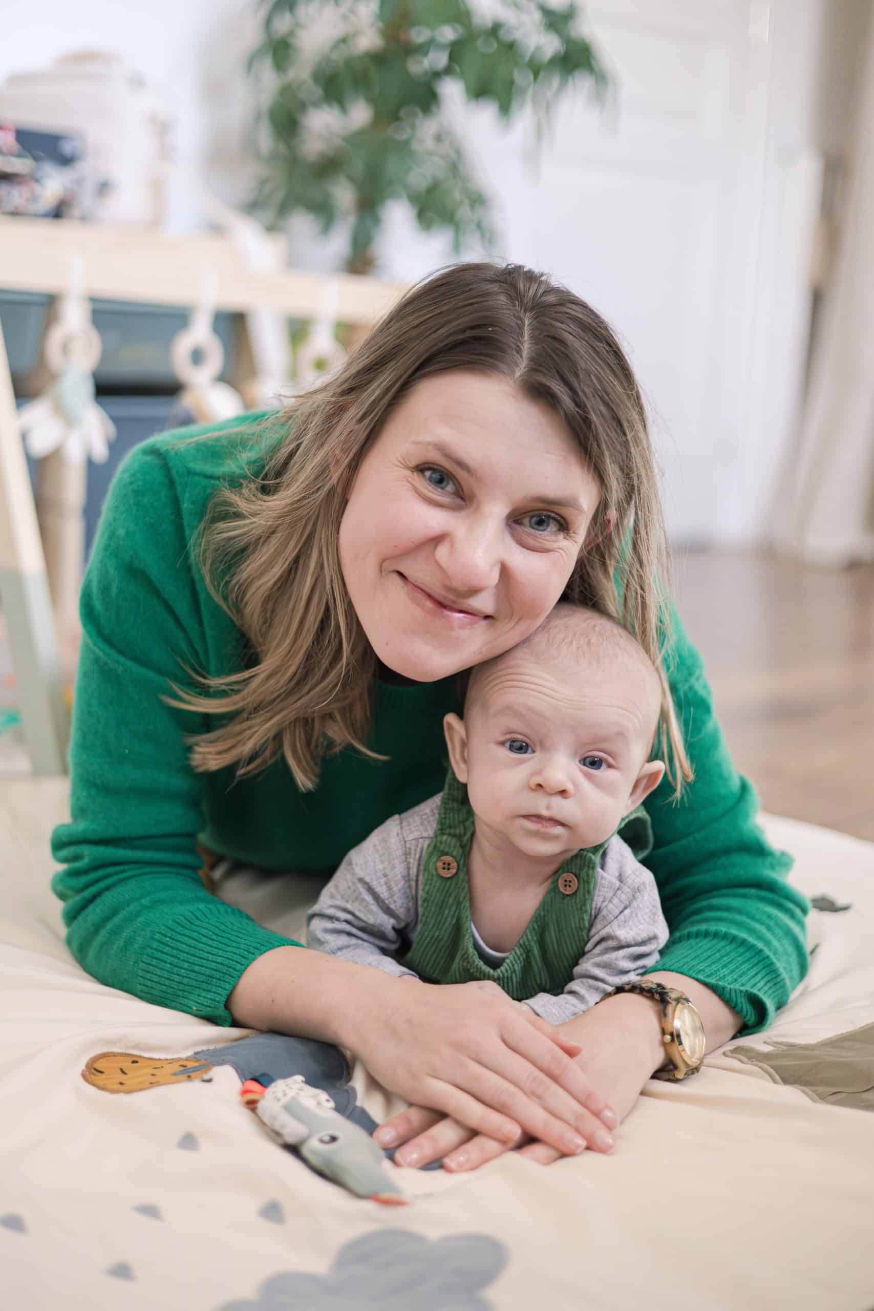 une femme avec son b&eacute;b&eacute; posent pour les photos, le b&eacute;b&eacute; est partairre et la femme sourie