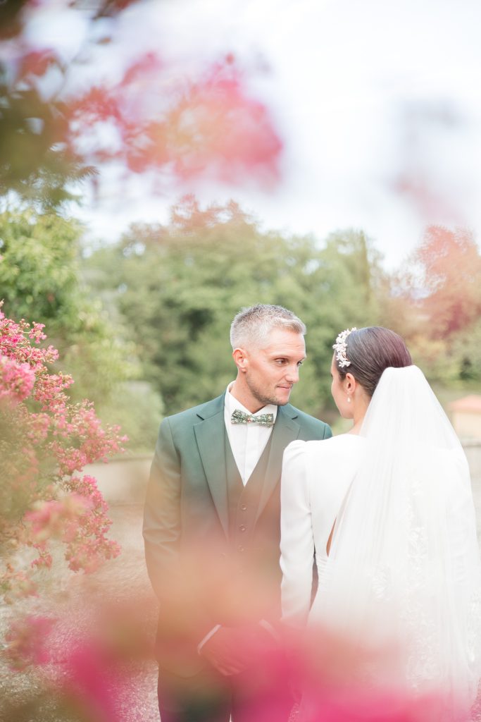 un couple de mari&eacute;s sont &agrave; c&ocirc;t&eacute; des fleurs roses