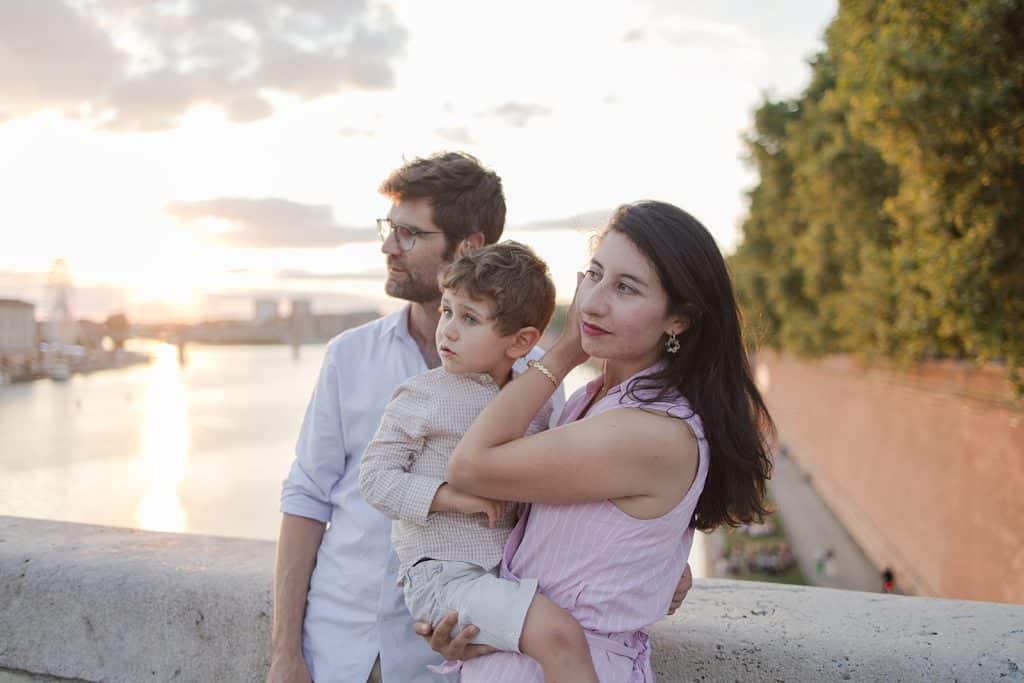 une famille sur un pont au coucher de soleil, un homme une femme et leur fils de 10 ans