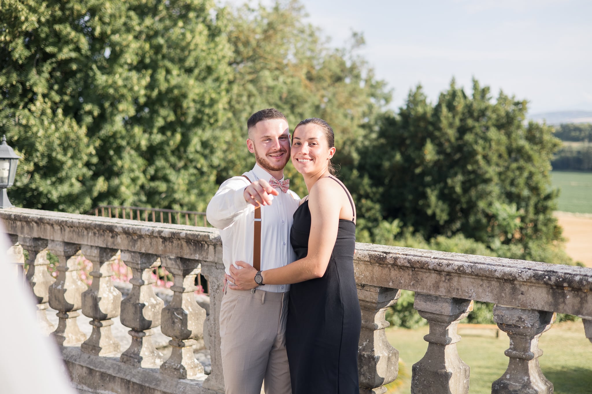 un couple qui montre avec le doigts la direction de la photo, ils se font un calin